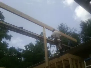 Carpenter setting a ridge beam over a new addition frame — Ice Dam Removal by Roofing Brothers in Camp Hill