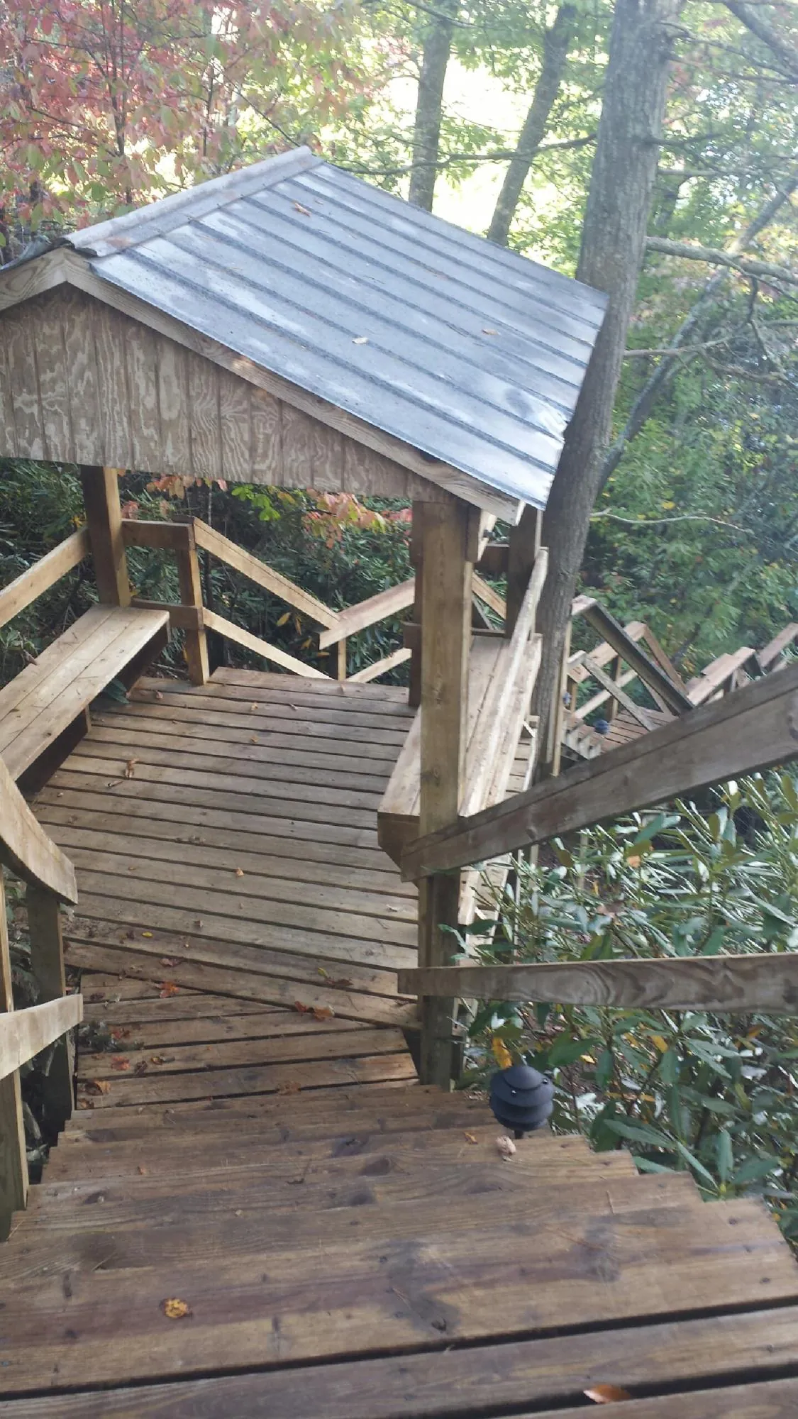 Metal roofed shelter over wooden steps on a wooded walkway — Skylight Repair & Installation work by our crew in Camp Hill